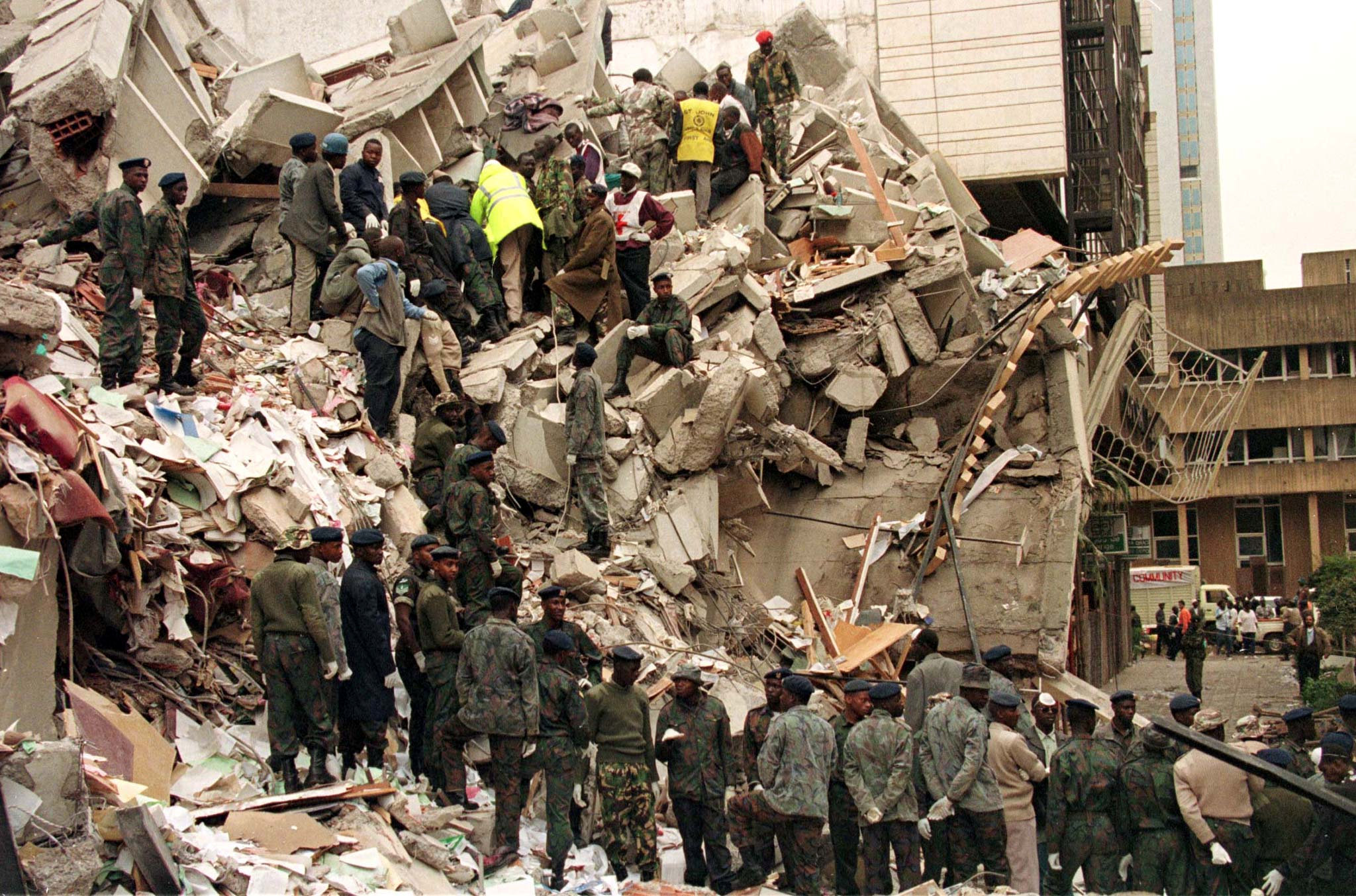 FILE PHOTO: Rescue workers sift through rubble and slabs of concrete in an attempt to find survivers at the site of the bombing of the U.S. Embassy building in Nairobi, Kenya. August 7, 1998. Picture taken August 7, 1998. REUTERS/Corinne Dufka/File photo