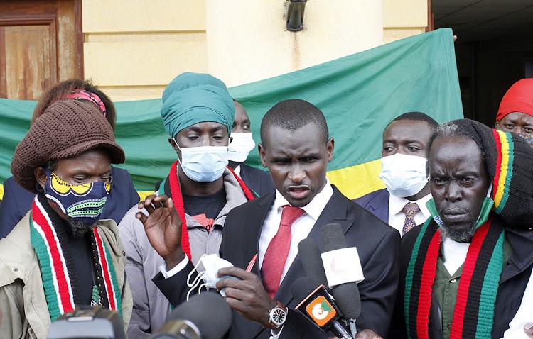 Lawyer Shadrack Wambui (centre) is pictured with members of the Ras Tafari Society of Kenya (RSK) at the Milimani Law Courts in Nairobi on May 17, 2021.