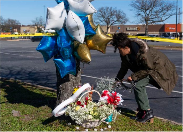 A grieving family member scatters flowers close to the Walmart store shooting scene in Chesapeake, Virginia.