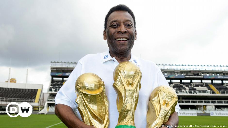 Pele holding his 3 world cup trophies won for Brazil